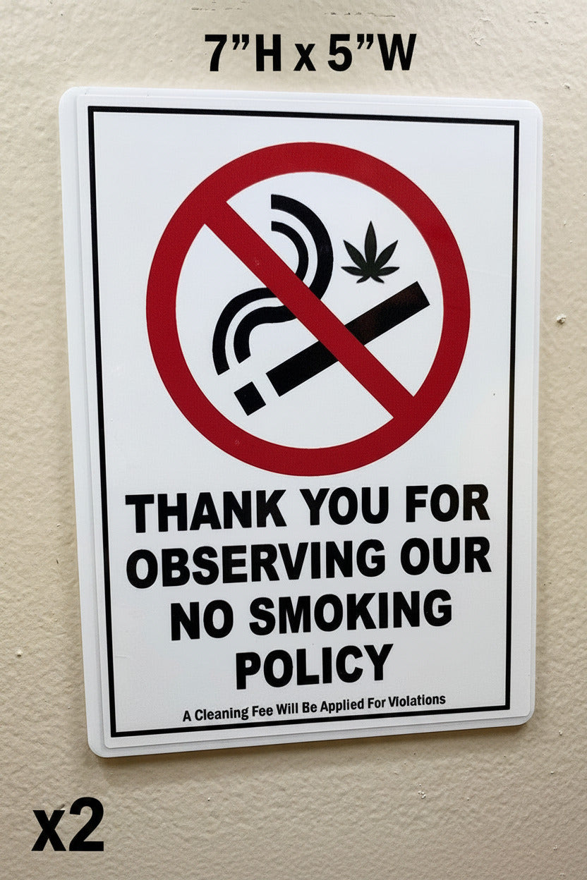 A rectangular white sign with rounded corners mounted on a beige wall. The sign features a red and black 'no smoking' symbol crossed out with a cannabis leaf, above the text 'THANK YOU FOR OBSERVING OUR NO SMOKING POLICY' and smaller text at the bottom.